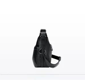 Side view detail of black pebble leather crossbody bag with silver hardware and strap
