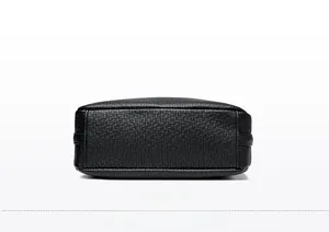 Detailed macro view of the lychee grain leather bottom and stitching on a black crossbody bag