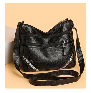 Dettaglio della borsa in morbida pelle PU nera con tasche multiple a zip e decori rivet