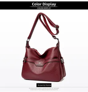 Detail of wine red shoulder bag with pebble grain texture and adjustable strap