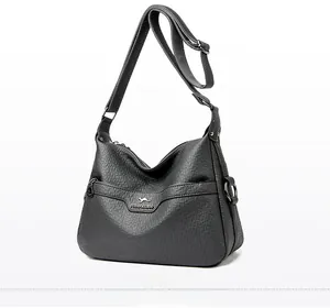 Close-up of gray lychee-textured faux leather bag with metal logo and zipper detail