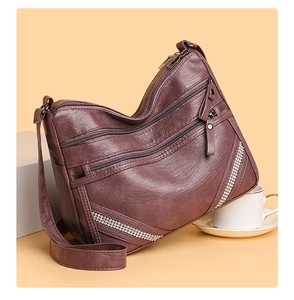 Dettaglio borsa in ecopelle viola con trama a litchi e accenti di strass argentati lucidi