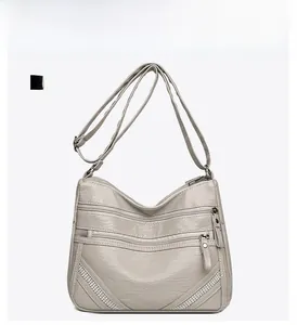 Dettaglio borsa a tracolla grigio chiaro in ecopelle con multi-zip e borchie decorate