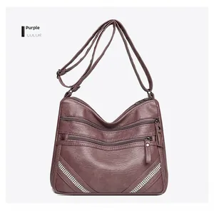 Dettaglio borsa viola in ecopelle martellata con decorazioni di strass a forma di V