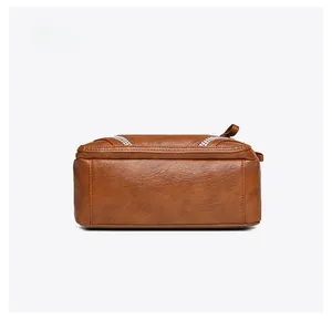 Dettaglio del fondo della borsa in pelle marrone con cuciture fini e accenti di cristallo