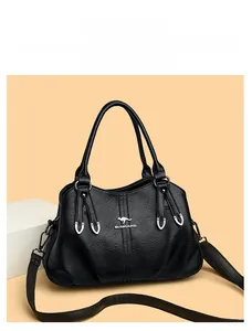 Detail of black lychee grain PU leather handbag with silver kangaroo logo and stitching