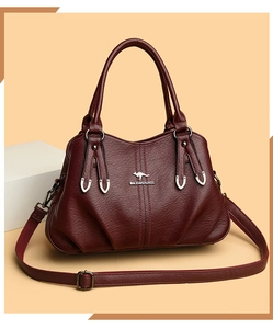 Close-up of wine red textured leather handbag with gold kangaroo logo and U-shaped metal hardware