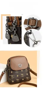 Détails d'un petit sac bandoulière marron avec ferrures argentées brillantes et texture en cuir