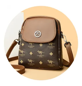 Détail d'un petit sac bandoulière avec motif monogramme marron et logo kangourou rond