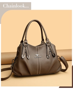 Detail of soft brown pebble leather handbag with silver logo and metallic hardware accents