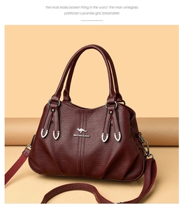 Close-up of wine red leather handbag featuring pebbled texture and silver kangaroo logo