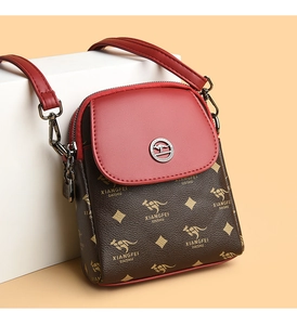 Détail d'un petit sac bandoulière rouge et marron pour téléphone avec motif kangourou