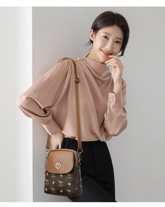 Détail de la mini sacoche bandoulière avec imprimé kangourou sur un haut en soie rose