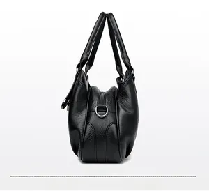 Detail of soft leather handbag side view with three zipper pockets and D-ring hardware