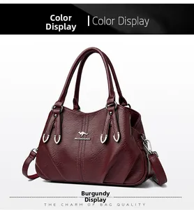 Detail view of burgundy soft leather texture and kangaroo metal logo on handbag