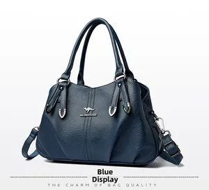Detail of blue textured leather handbag featuring a silver kangaroo logo and hardware
