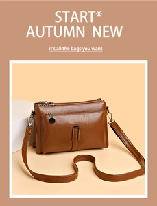 Detail of a brown leather crossbody bag with multiple metal zippers and front pockets