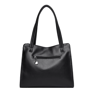 Borsa a mano classica in pelle nera con trama litchi e ciondolo a cuore su sfondo bianco