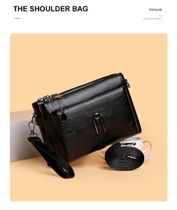 Detail of black PU leather shoulder bag with multiple compartments and detachable straps