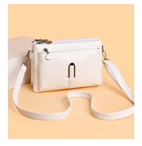 Detailed view of the white three-layer zipper crossbody bag with silver hardware accents