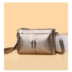 Detail of vintage bronze crossbody bag with multiple zippers and metallic crinkled leather