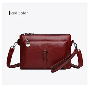 Macro shot of red pebble faux leather shoulder bag with round silver metal zipper detail