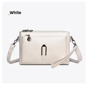 Detailed view of white PU leather crossbody bag with triple zippers and multiple compartments