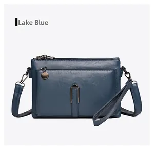 Detail of lake blue multi-layer leather crossbody bag with three zippers and hardware