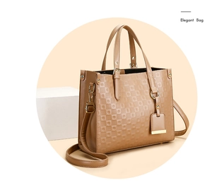 Détail de la texture géométrique gaufrée et bandoulière réglable sur un sac cabas