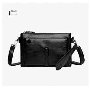 Detailed view of the black textured leather crossbody bag with adjustable shoulder strap