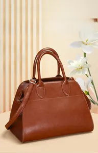 Detail of tan faux leather tote with dual round handles and adjustable shoulder strap