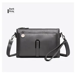 Front detail of a dark grey lychee pattern leather shoulder bag with metal buckle and strap