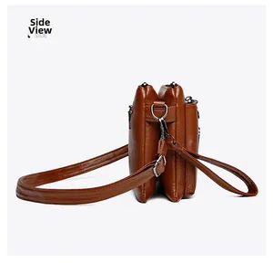 Side view of dark brown crossbody bag showing multi-layered zippers and hardware