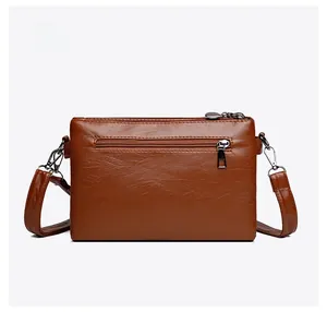 Rear view of brown faux leather shoulder bag featuring back zipper pocket and silver hardware