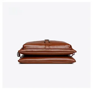 Detailed bottom view of brown leather shoulder bag showing stitching and metal hardware