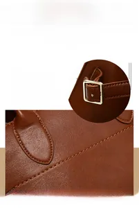 Detail of brown leather tote showing fine texture, precise stitching and gold buckle