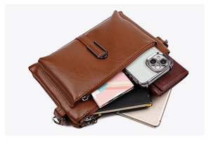 Detailed top view of a dark brown multi-compartment leather bag with metal zippers