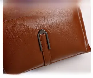 Detailed macro view of dark brown lychee grain leather with a metal buckle and stitching
