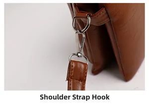Detail of silver metal hook and litchi grain leather on a brown crossbody bag