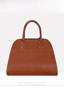 Detailed front view of brown leather tote bag with visible stitching and round handles