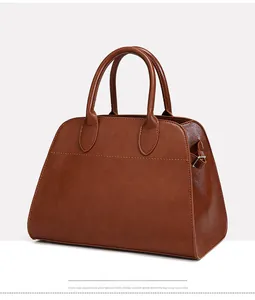 Detailed view of the brown leather tote bag showing fine stitching and metal buckles