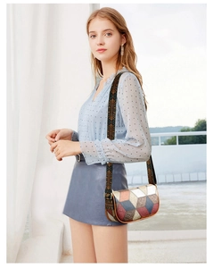 Detail of colorful geometric pattern faux leather bag with ethnic embroidered strap