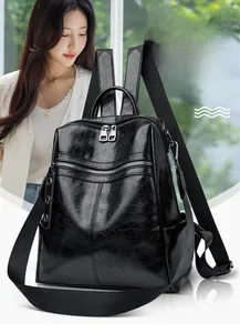 Close-up of black glossy textured leather backpack with multiple zipper compartments