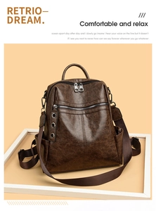 Close-up of vintage dark brown faux leather backpack with rich oily texture and zippers
