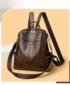 Close-up of vintage dark brown faux leather texture and dual zipper detail on backpack