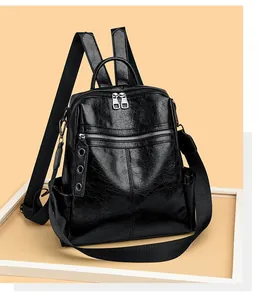 Detail of black pebbled leather backpack with silver zippers and removable fabric strap