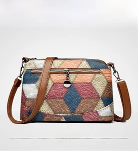Front view of geometric patchwork crossbody bag with multi-texture leather panels
