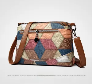 Side view of multi-colored faux leather crossbody bag with dual zippers and textures