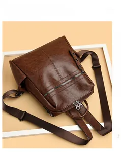 Detail of vintage brown pebble faux leather backpack with multiple zipper compartments