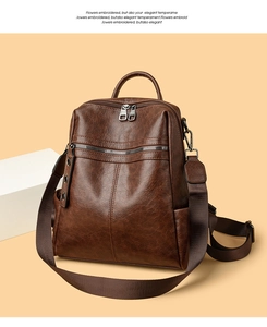 Detail view of brown vintage backpack with multiple zippers and detachable wide strap